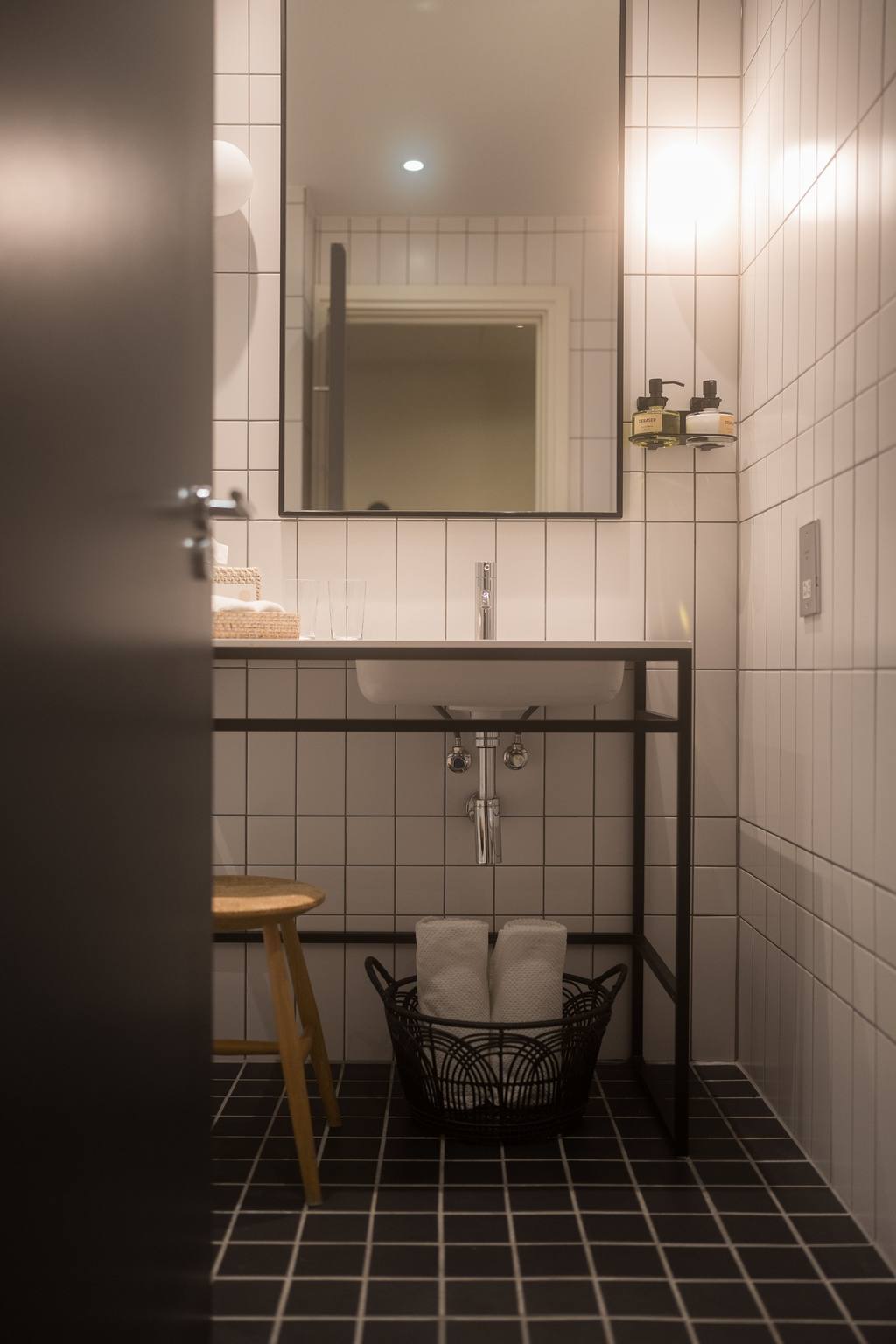 Renovated London bathroom with white wall tiles and black geometric floor